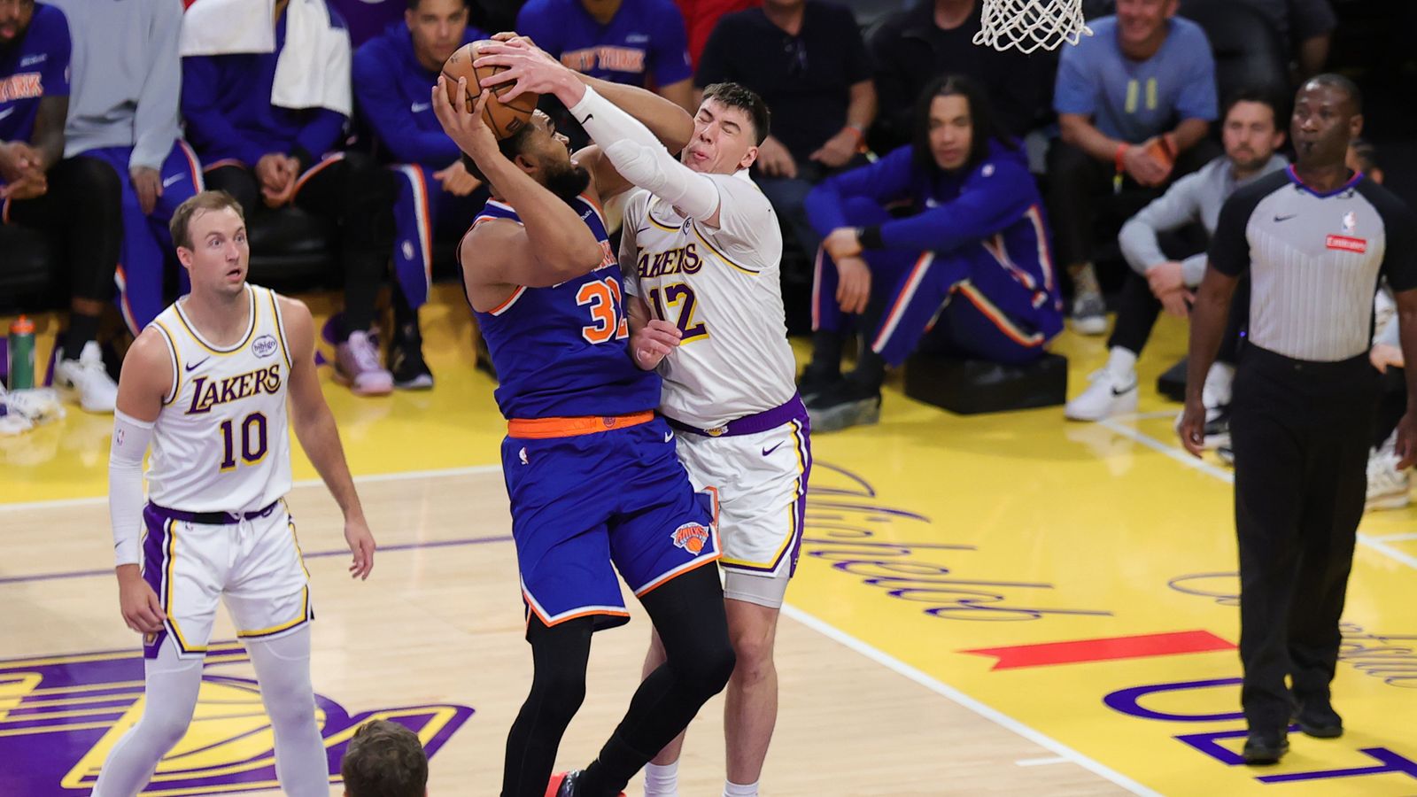 Los Angeles Lakers forward Jake LaRavia (12) defends against New York Knicks center Karl Anthony Townes (32) during an NBA game on March 8, 2026 in Los Angeles, CA.
