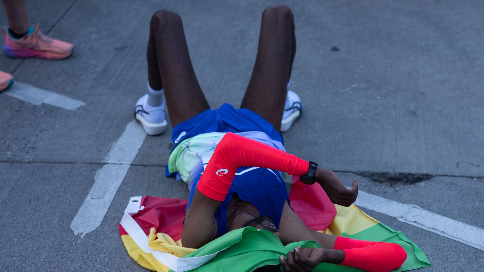 A runner rests on the pavement after finishing the Los Angeles Marathon on Sunday, March 8, 2026, in Los Angeles.