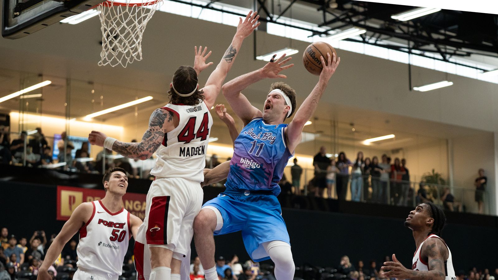 South Bay Lakers center Drew Timme (11) drives on hid defender