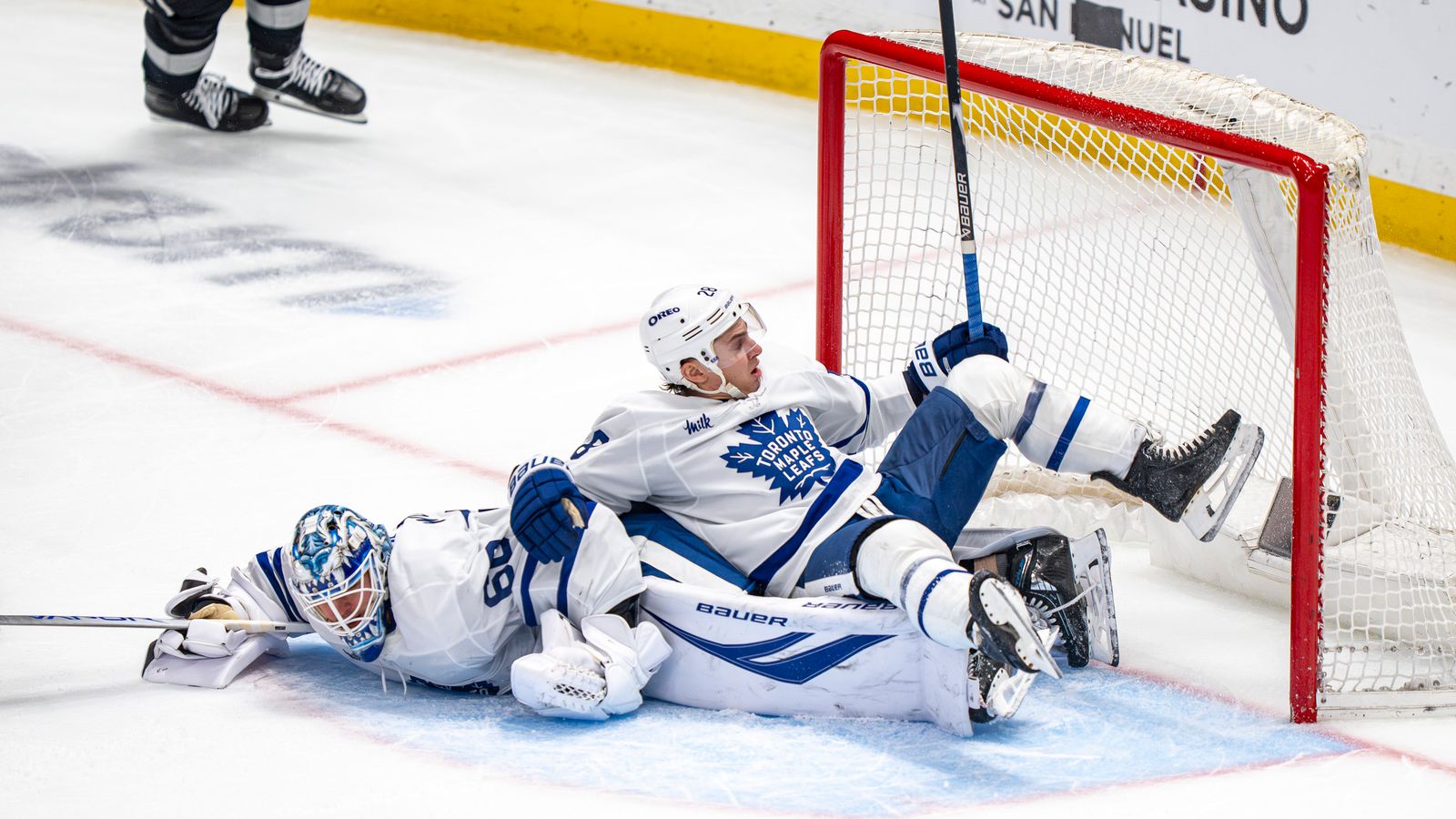 Maple Leafs Joseph Woll (60) and defenseman Troy Stecher (28) falling at their goal