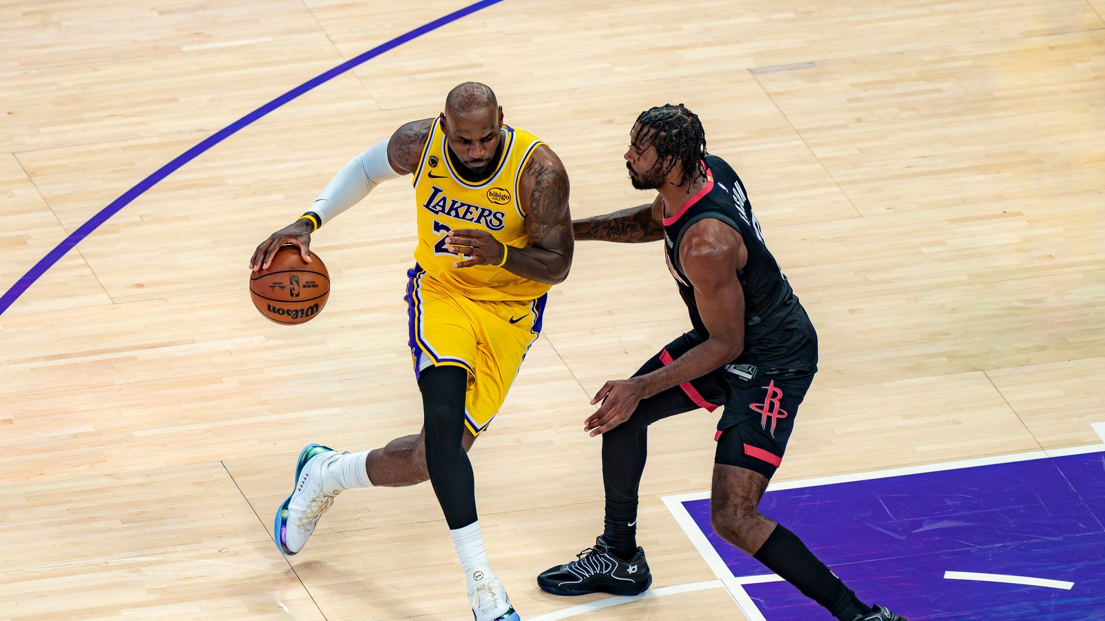 Lakers forward LeBron James (23) dribbling past a Rockets guard