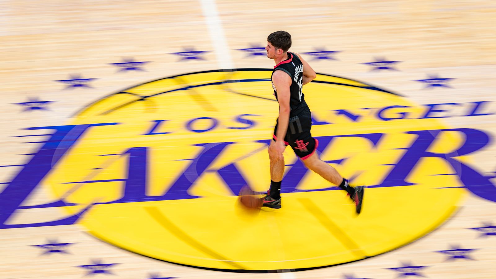 Rockets guard Reed Sheppard (15) dribbling over the center court logo