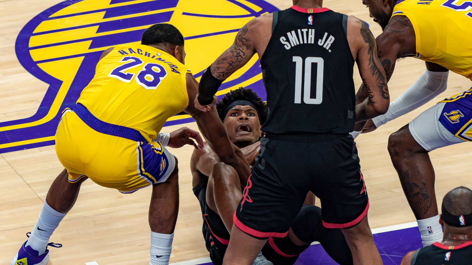 Lakers forward Rui Hachimura (28) helping a Rockets player to his feet