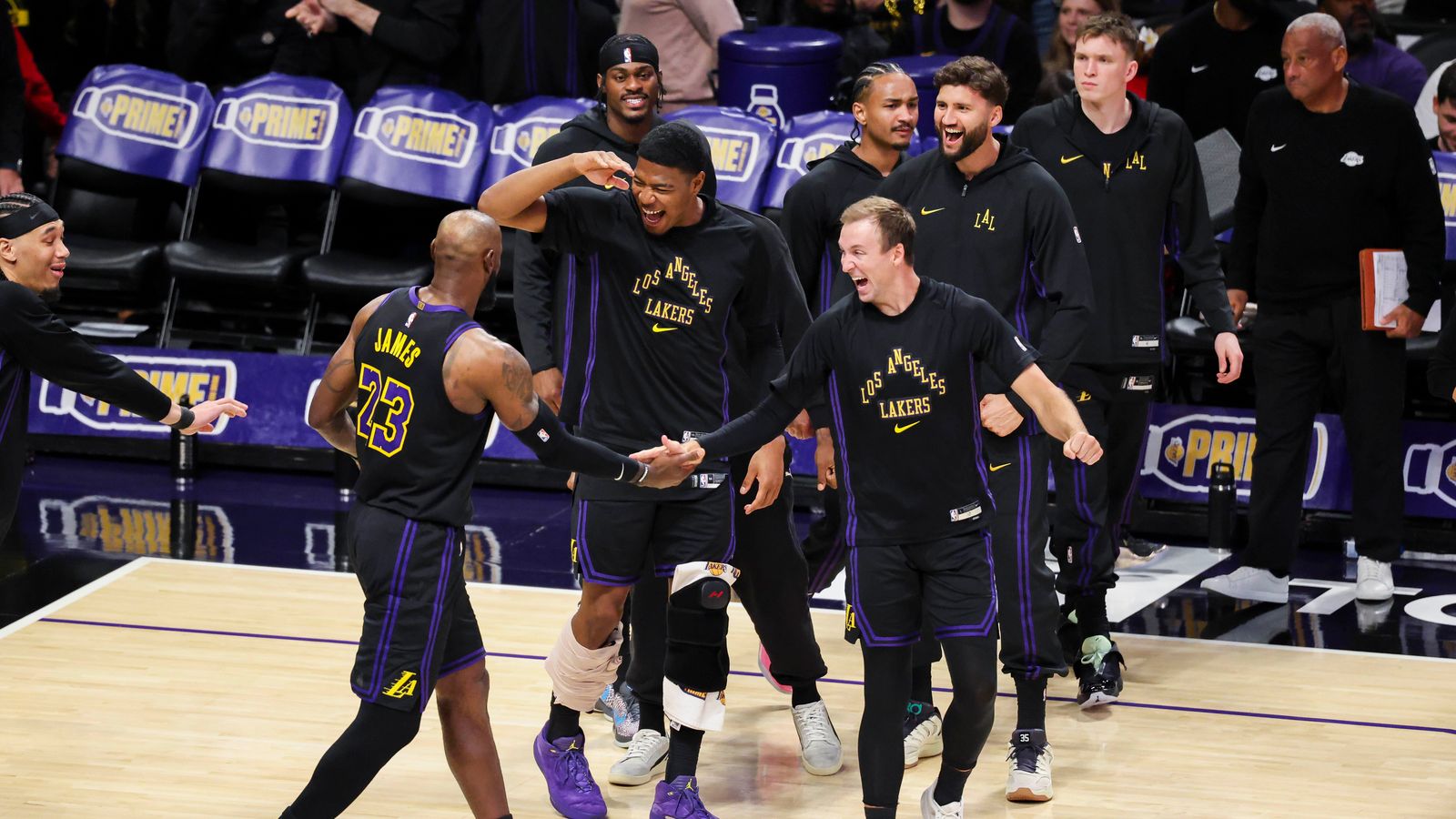 Team Celebration: The Lakers bench erupts for LeBron James during a historic performance
