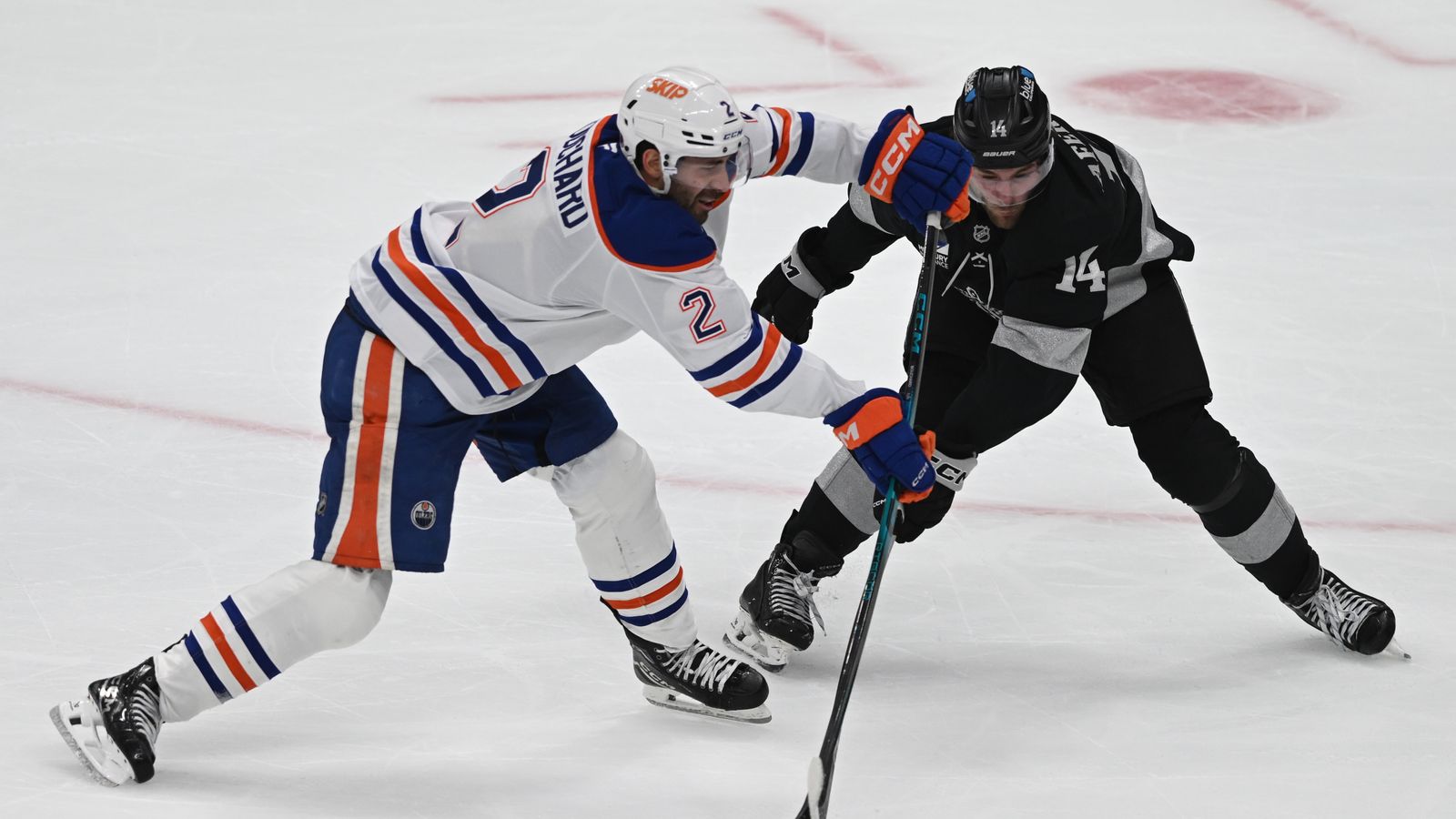 Oilers Evan Bouchard (2) and Kings Alex Laferriere (14) fight for possession