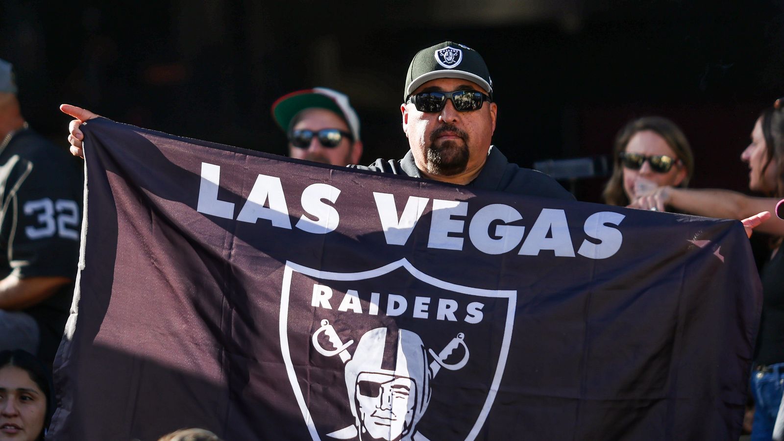 Fan Waves Las Vegas Raiders Flag During Draft Party Celebration