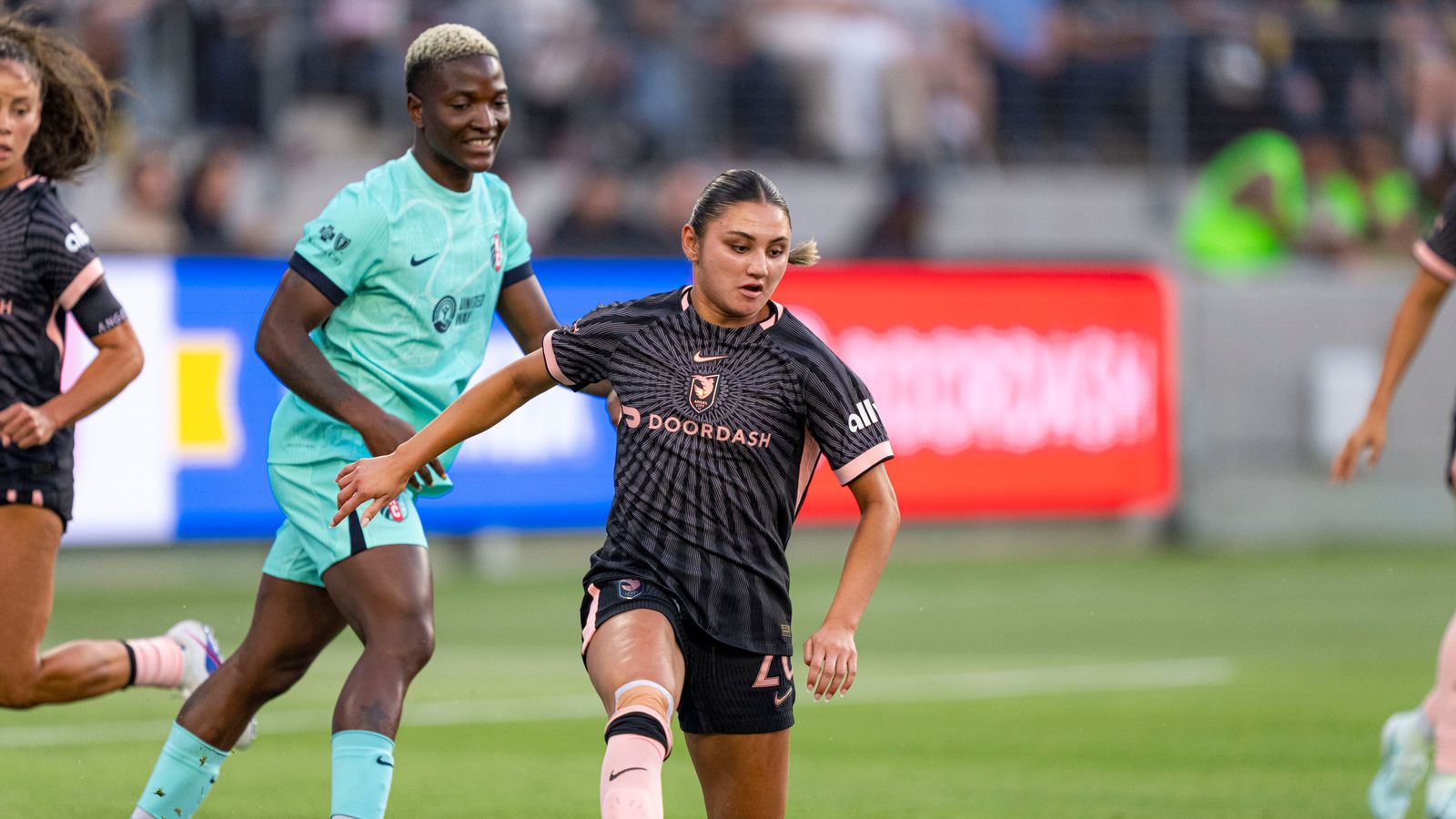 Gisele Thompson dribbles past defenders in NWSL clash