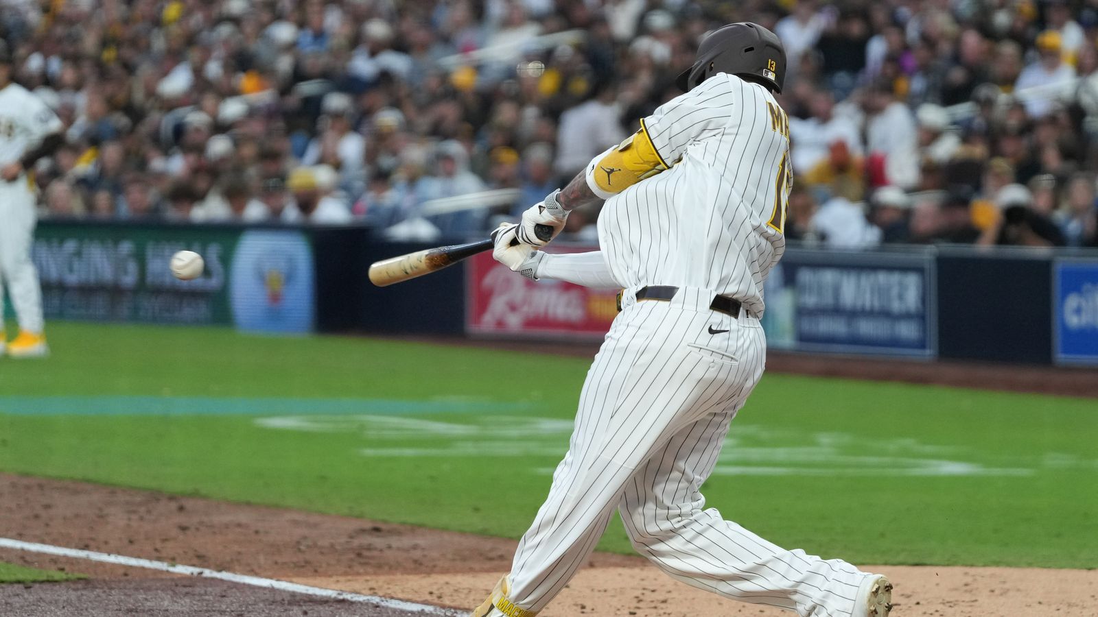 Padres third baseman Manny Machado (13) swings the bat