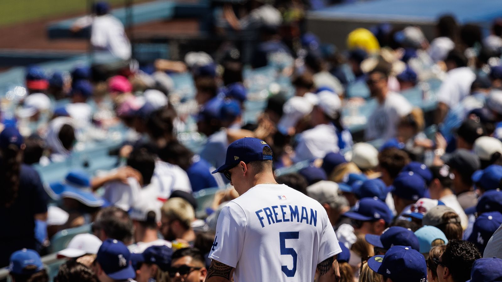 Fans in Freddie Freeman jerseys cheer at Dodgers Stadium.