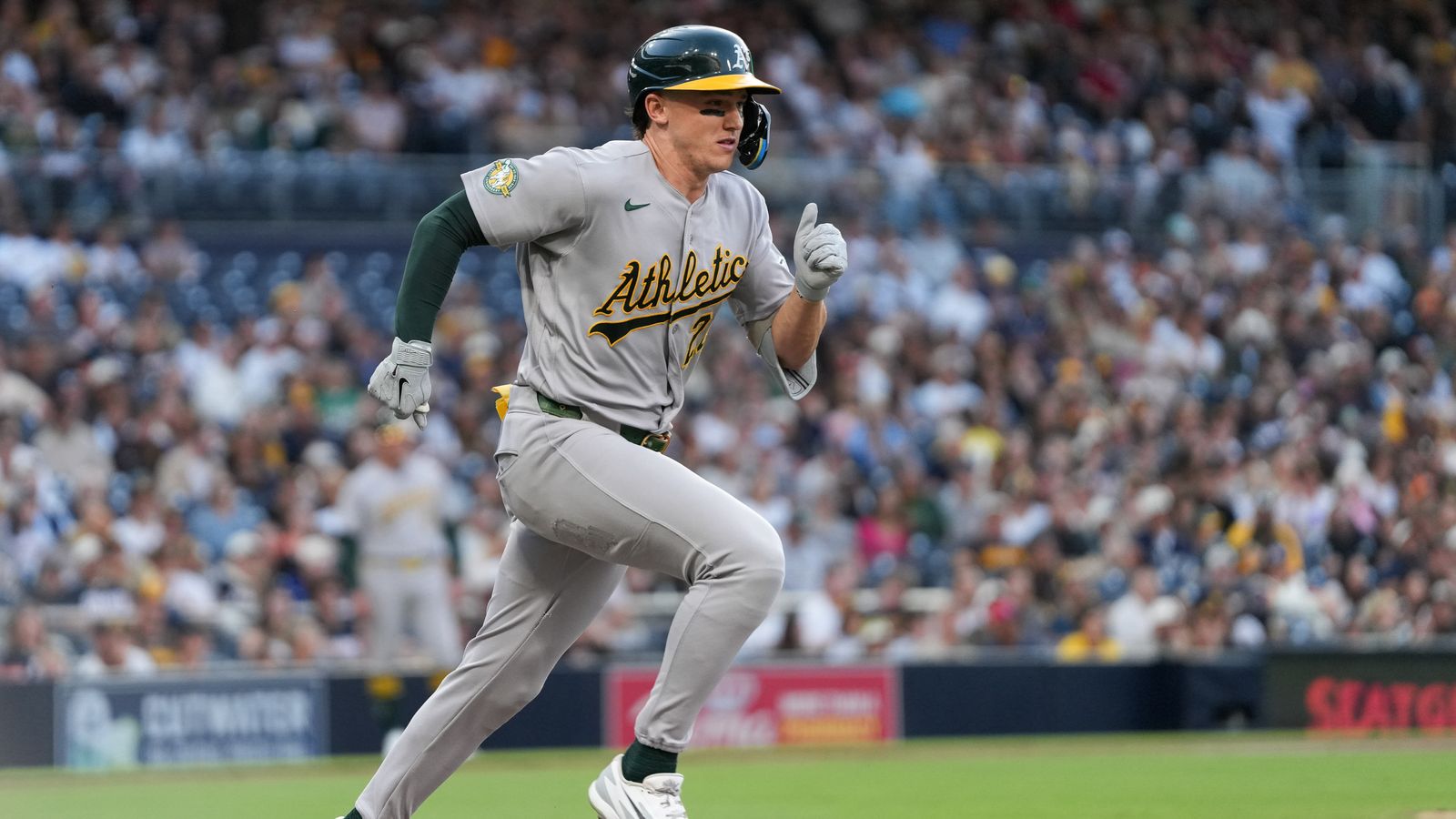 Zack Gelof hustles to first base in Padres vs Athletics game.
