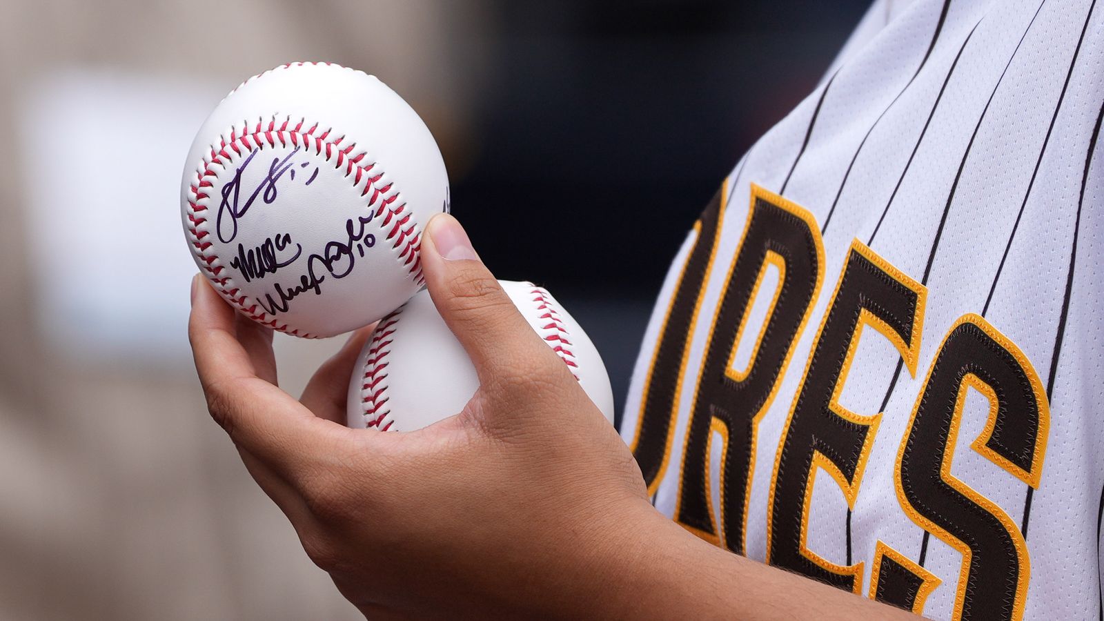 Padres fan with a signed baseball at Petco Park