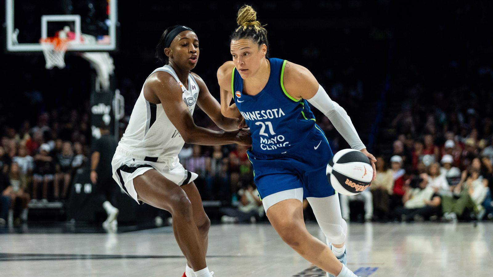 Kayla McBride dribbles under pressure from Jackie Young