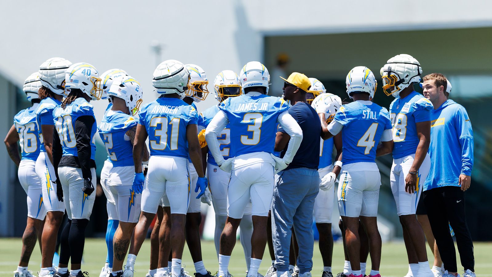 Chargers defense strategizes in a huddle at minicamp