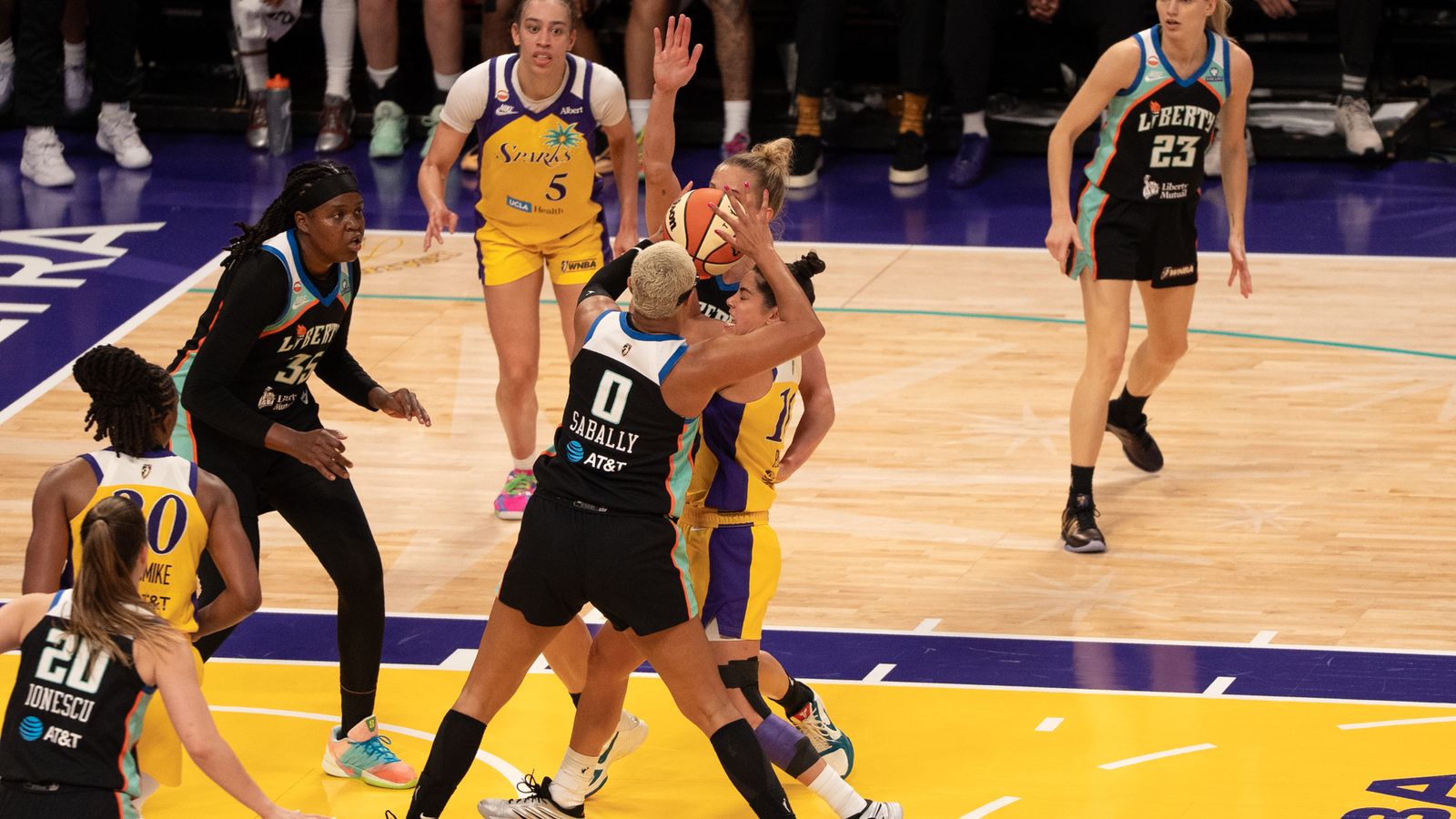Kelsey Plum maneuvers between defenders in a tense match