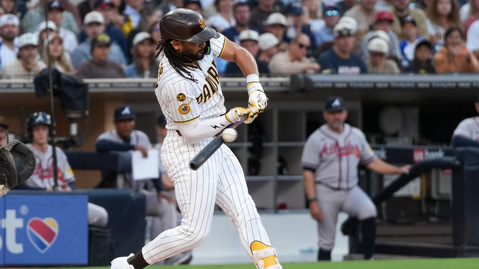 Fernando Tatis Jr. in action hitting the ball against the Braves