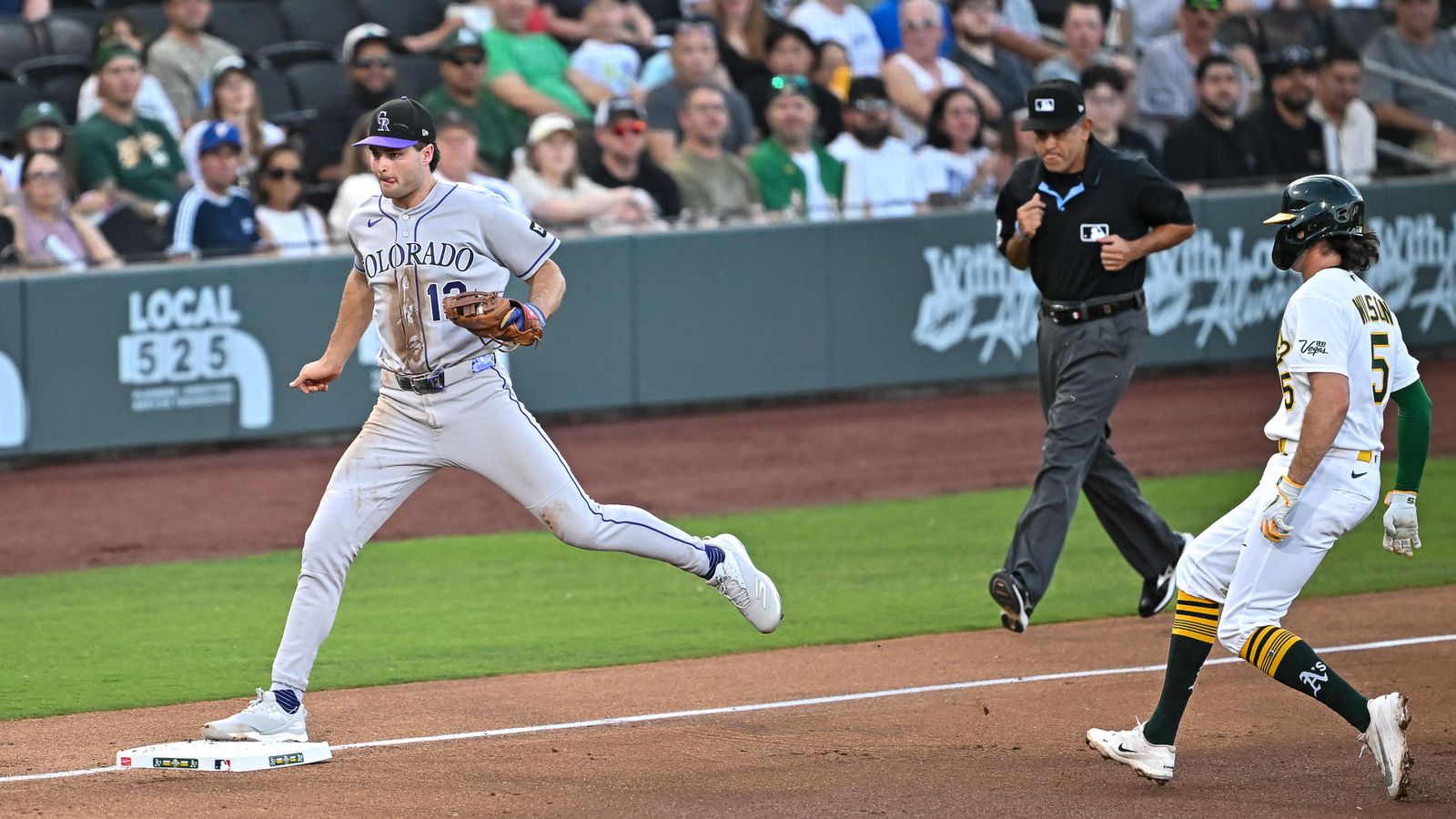 Rockies third baseman tags the bag at third.