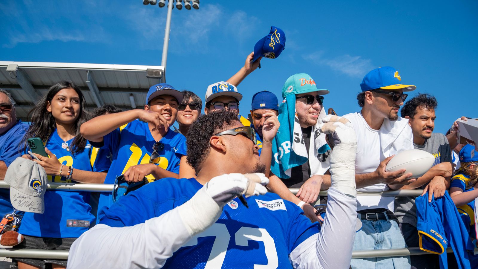 Steve Avila signs merchandise at Rams training camp