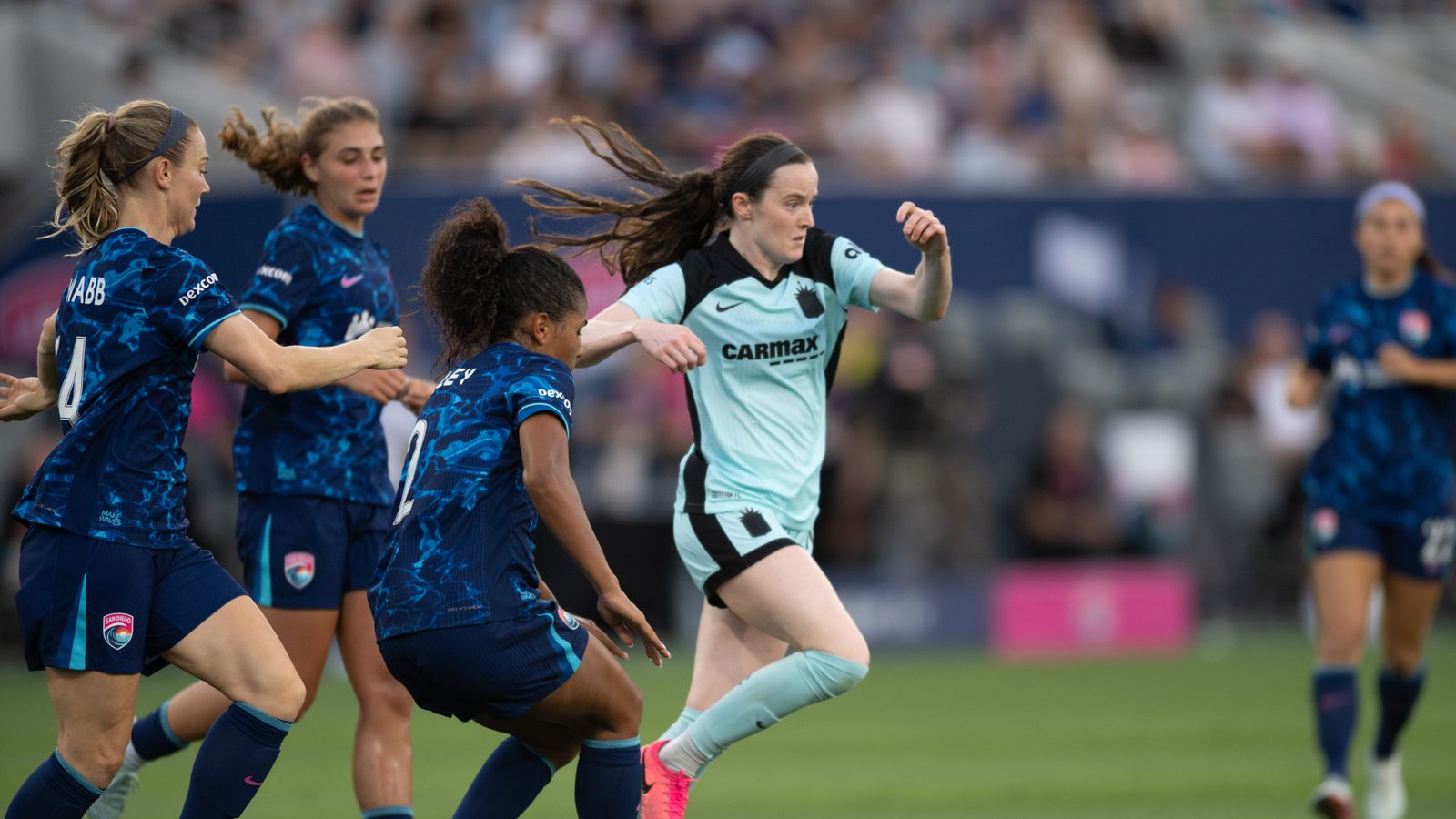 Rose Lavelle maneuvers past defenders in NWSL match
