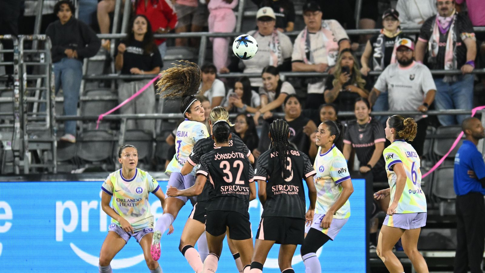 Angelina heads the ball in a crowded penalty area
