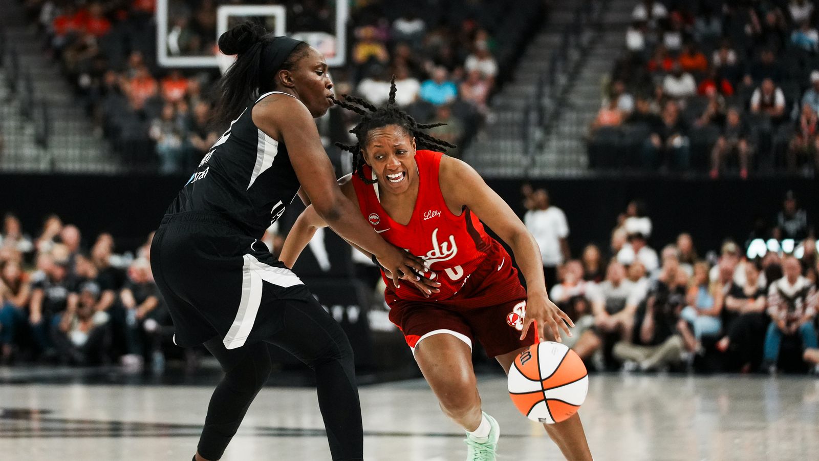 Kelsey Mitchell drives to the basket, guarded by Chelsea Gray