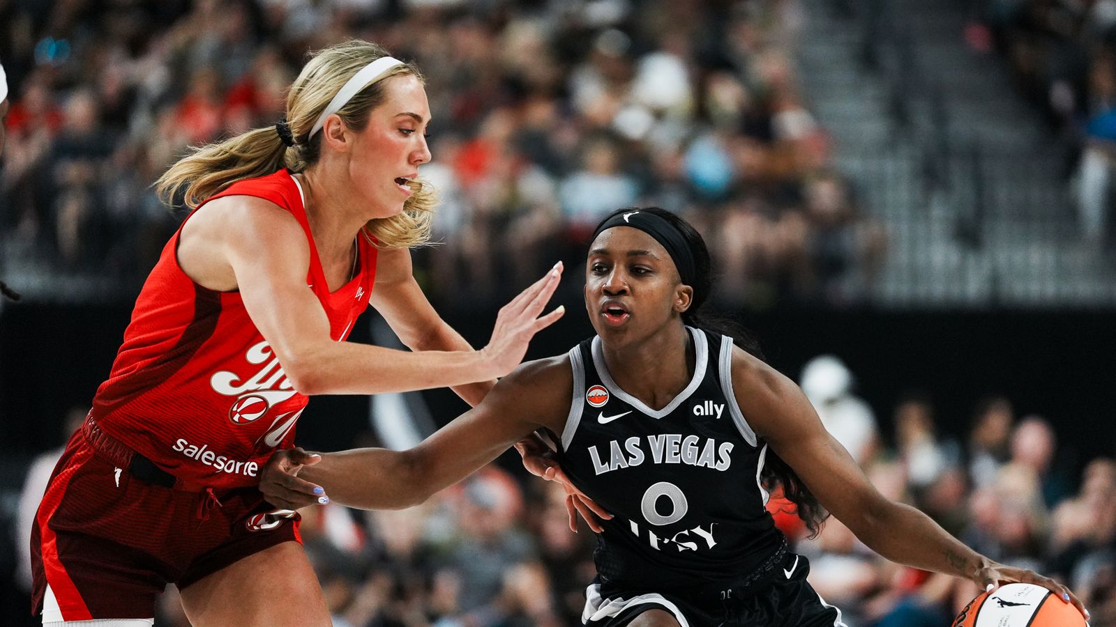 Jackie Young dribbles past Lexie Hull in a tense WNBA clash