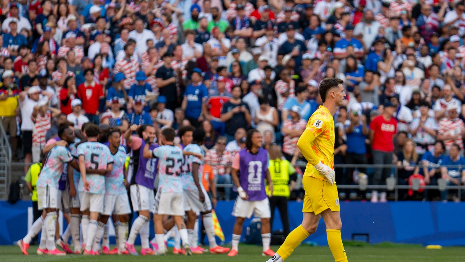 US goalie Matt Freese pauses as Belgium celebrates a goal.