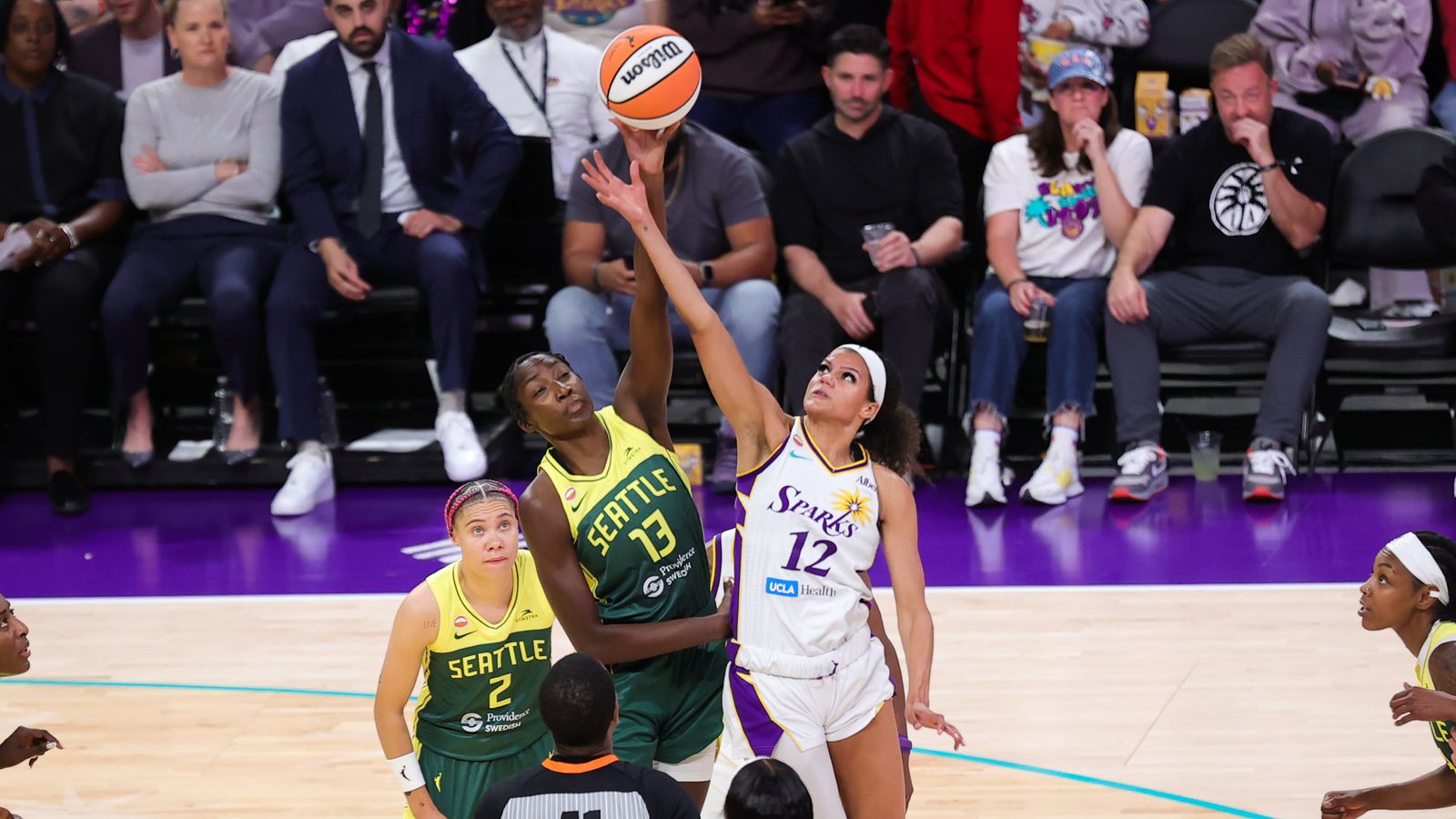 Rae Burrell and Ezi Magbegor jump ball at WNBA game.