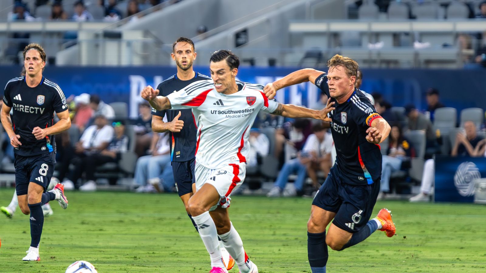 Petar Musa skillfully dribbles past Jeppe Tverskov in an intense moment.