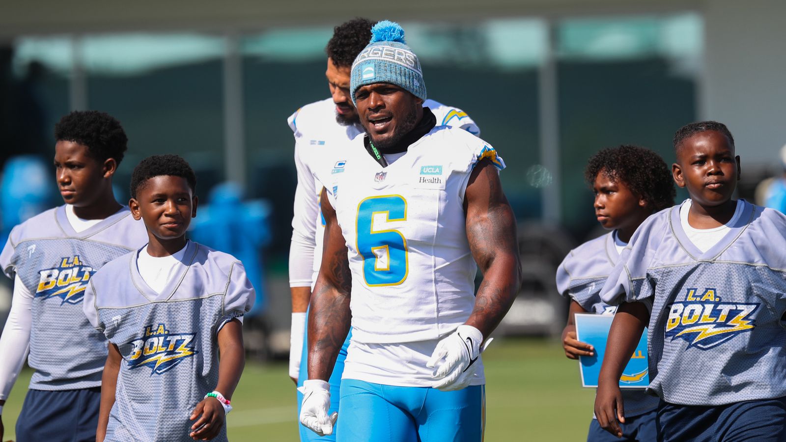 LB Denzel Perryman with youth players on the field