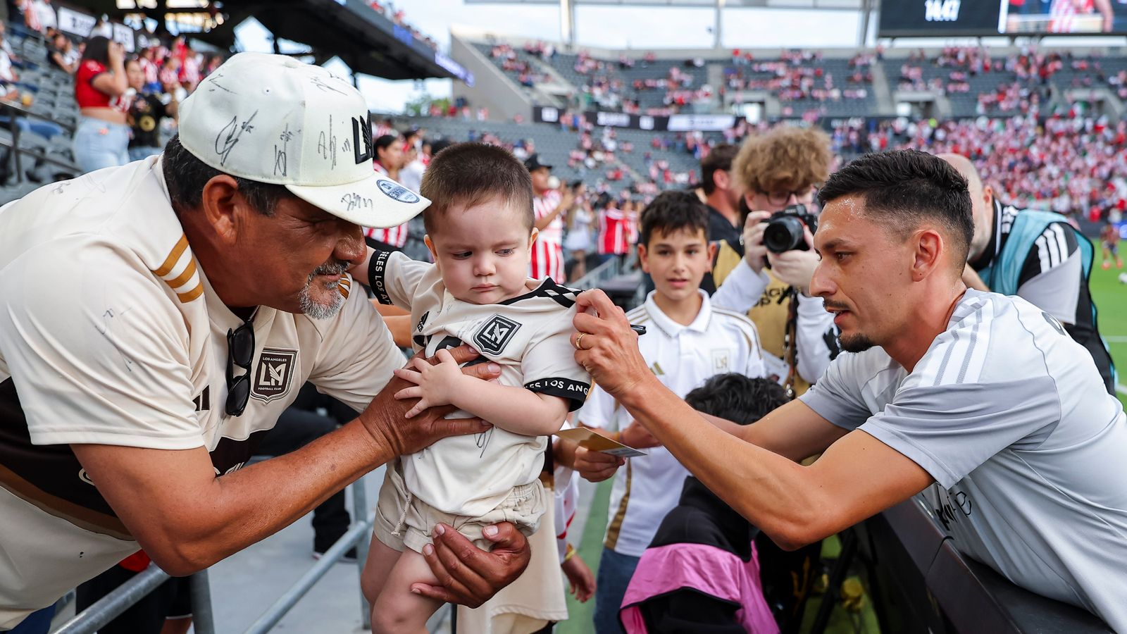 Mark Delgado of LAFC signs a jersey for a young fan