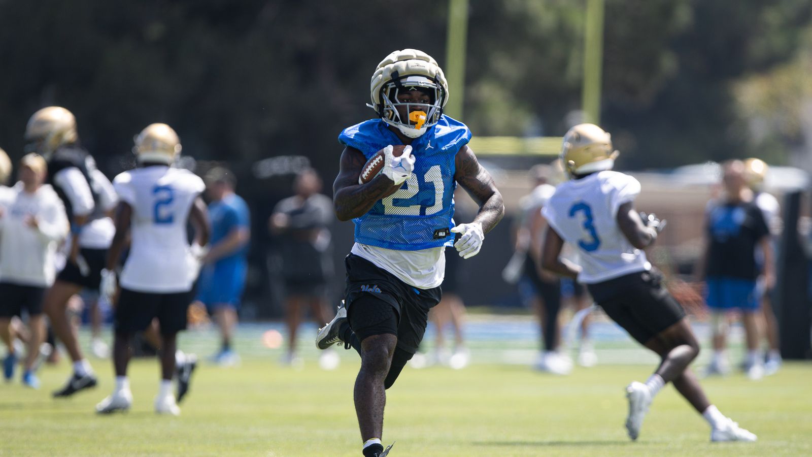 Jaivian Thomas takes a handoff at UCLA practice.