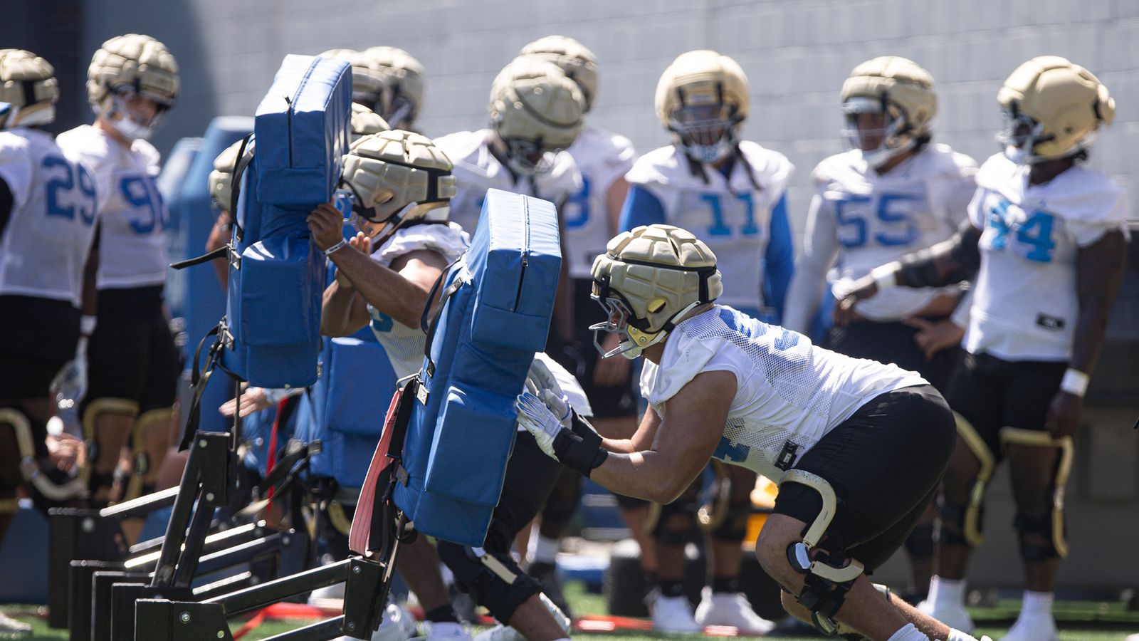 UCLA linemen engage with pads at practice in Los Angeles.