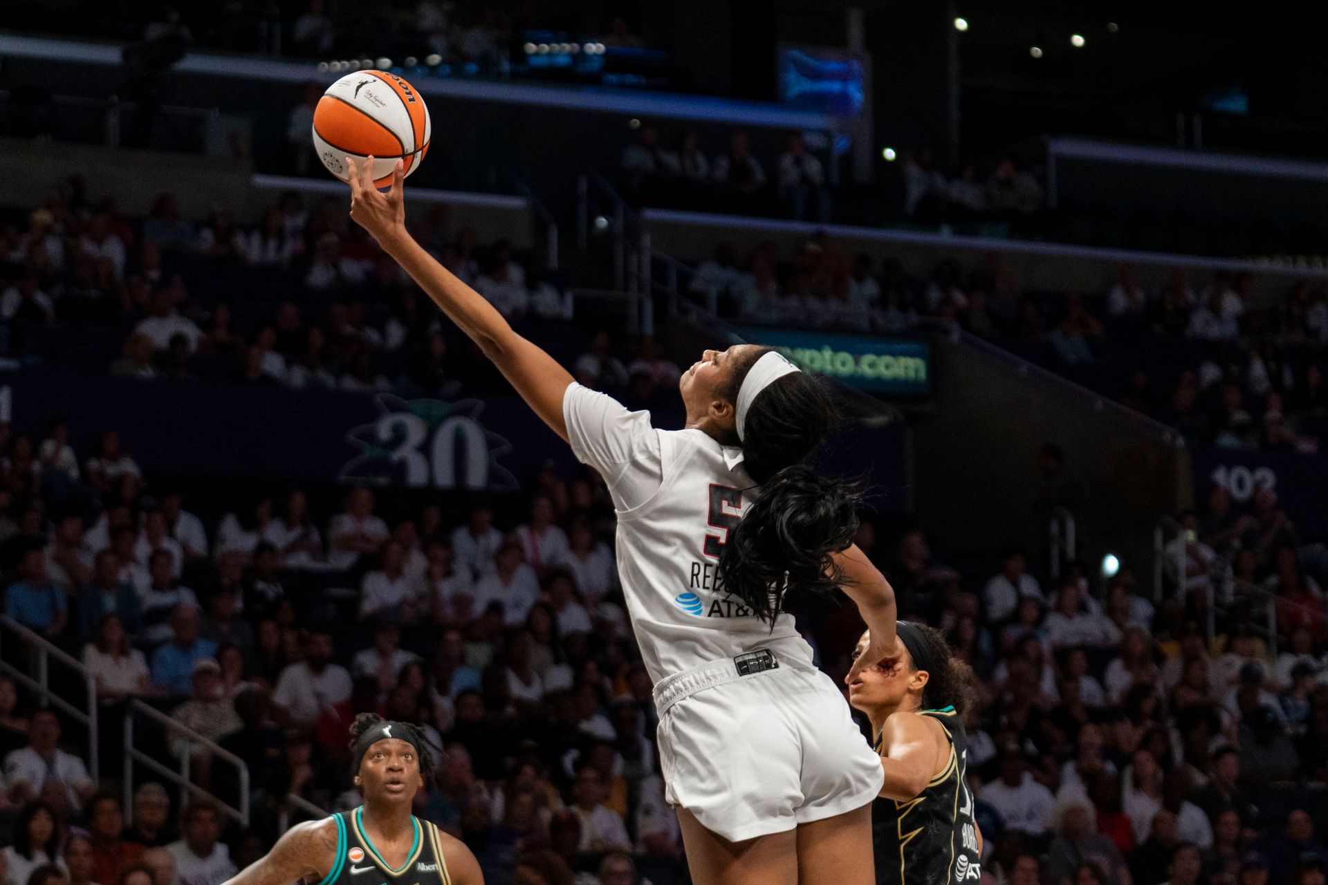 Angel Reese reaches for the ball in a dynamic play.