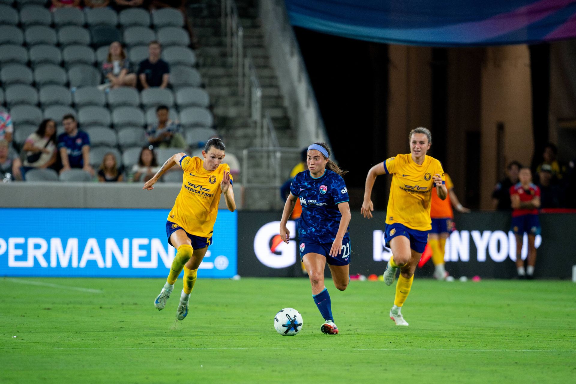 Lia Godfrey evades defenders in a dynamic NWSL match.