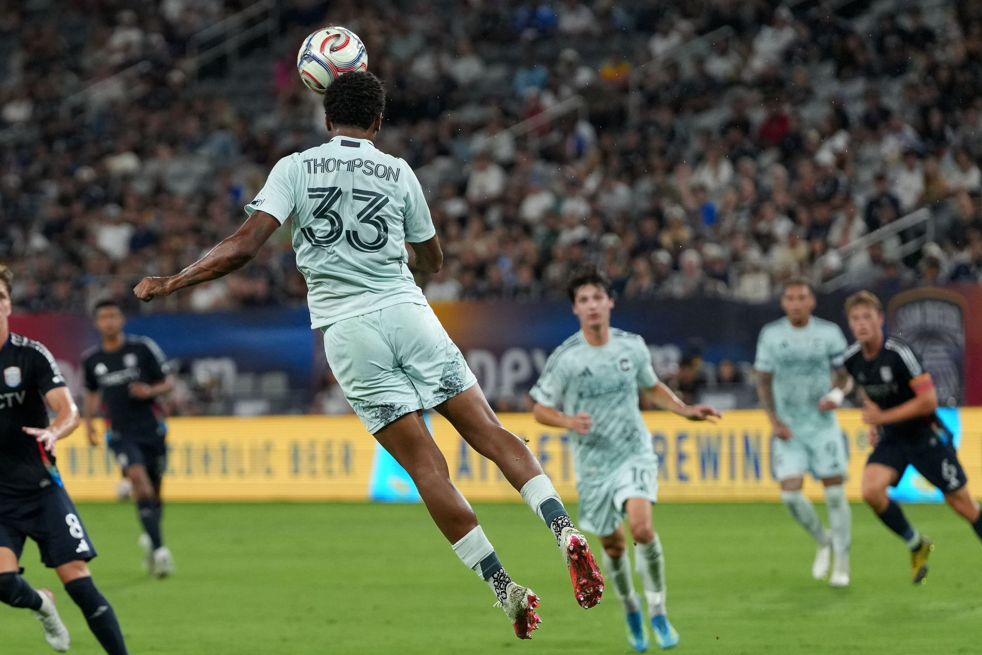 Kosi Thompson heads the ball in MLS match