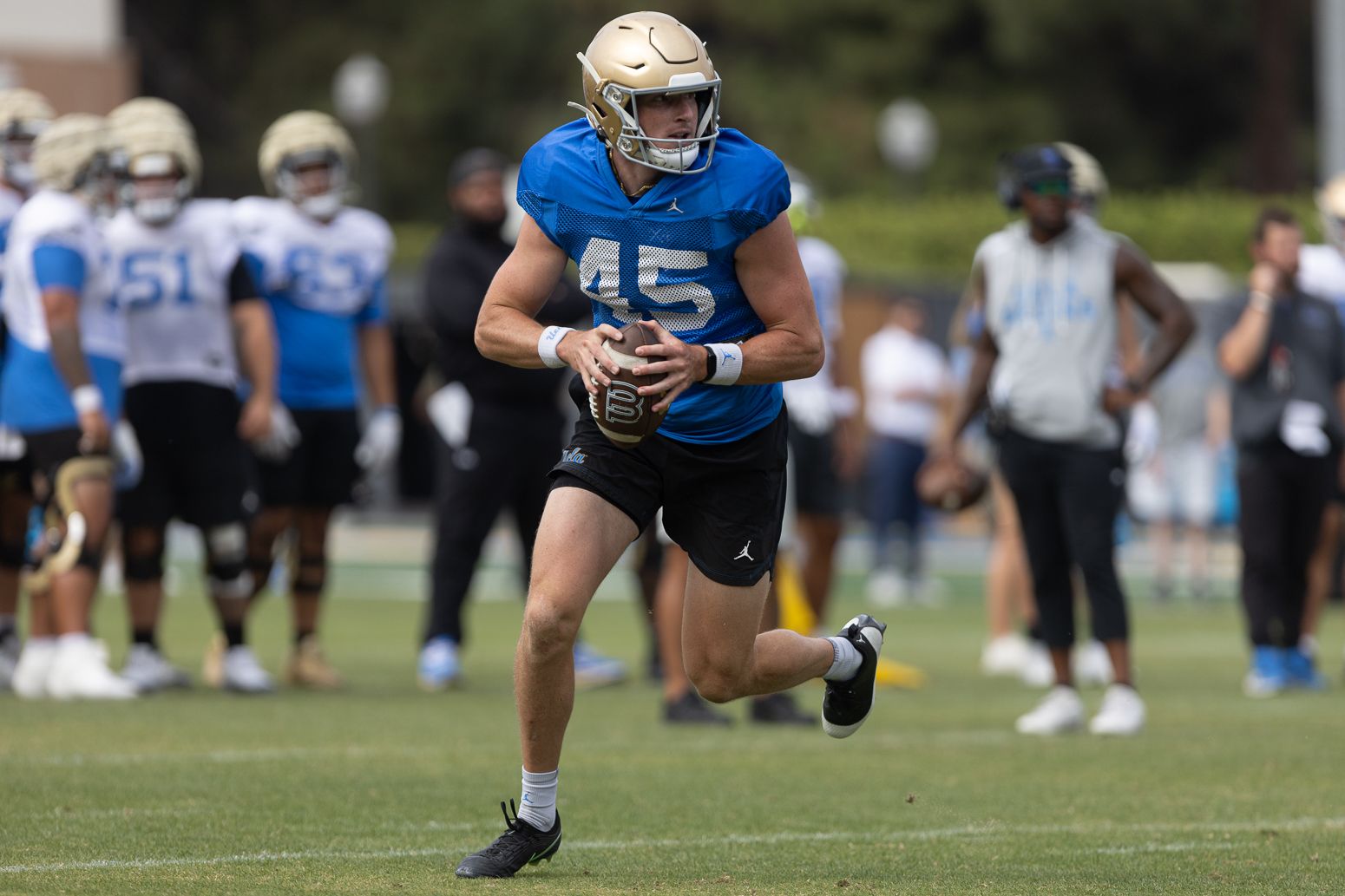 Chase Barry (45) executes a fake field goal at UCLA practice
