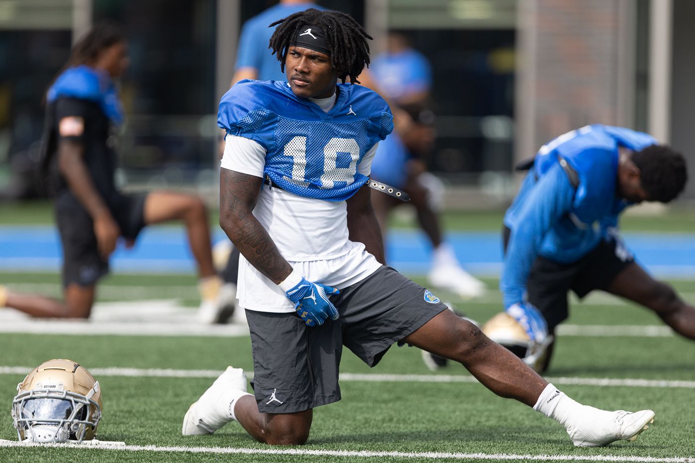 Osiris Gilbert (18) stretches at UCLA football practice, Los Angeles