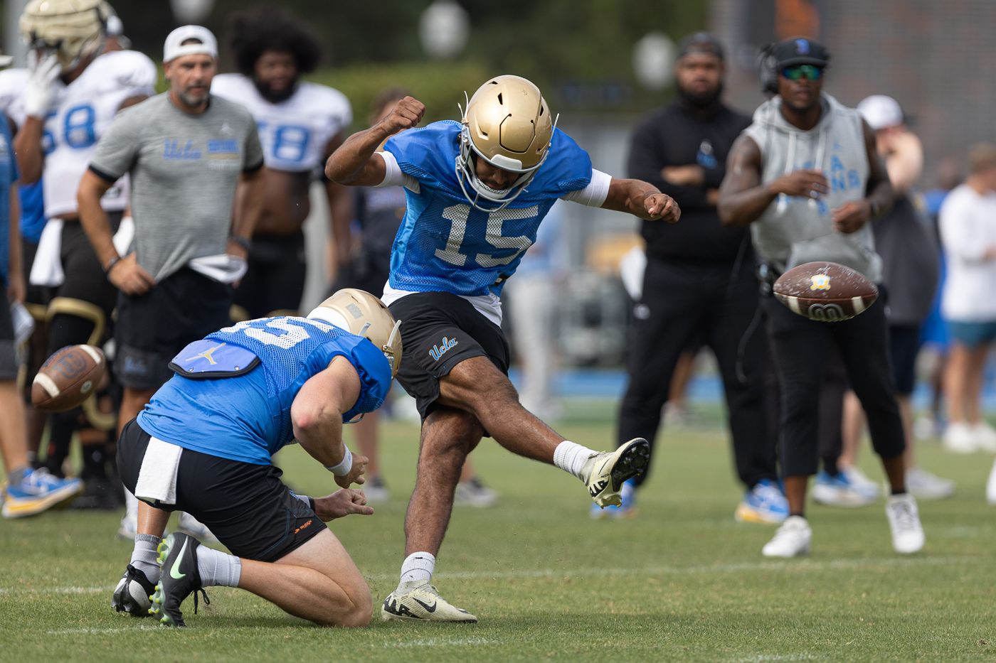 Mateen Bhaghani (15) kicks during UCLA football practice