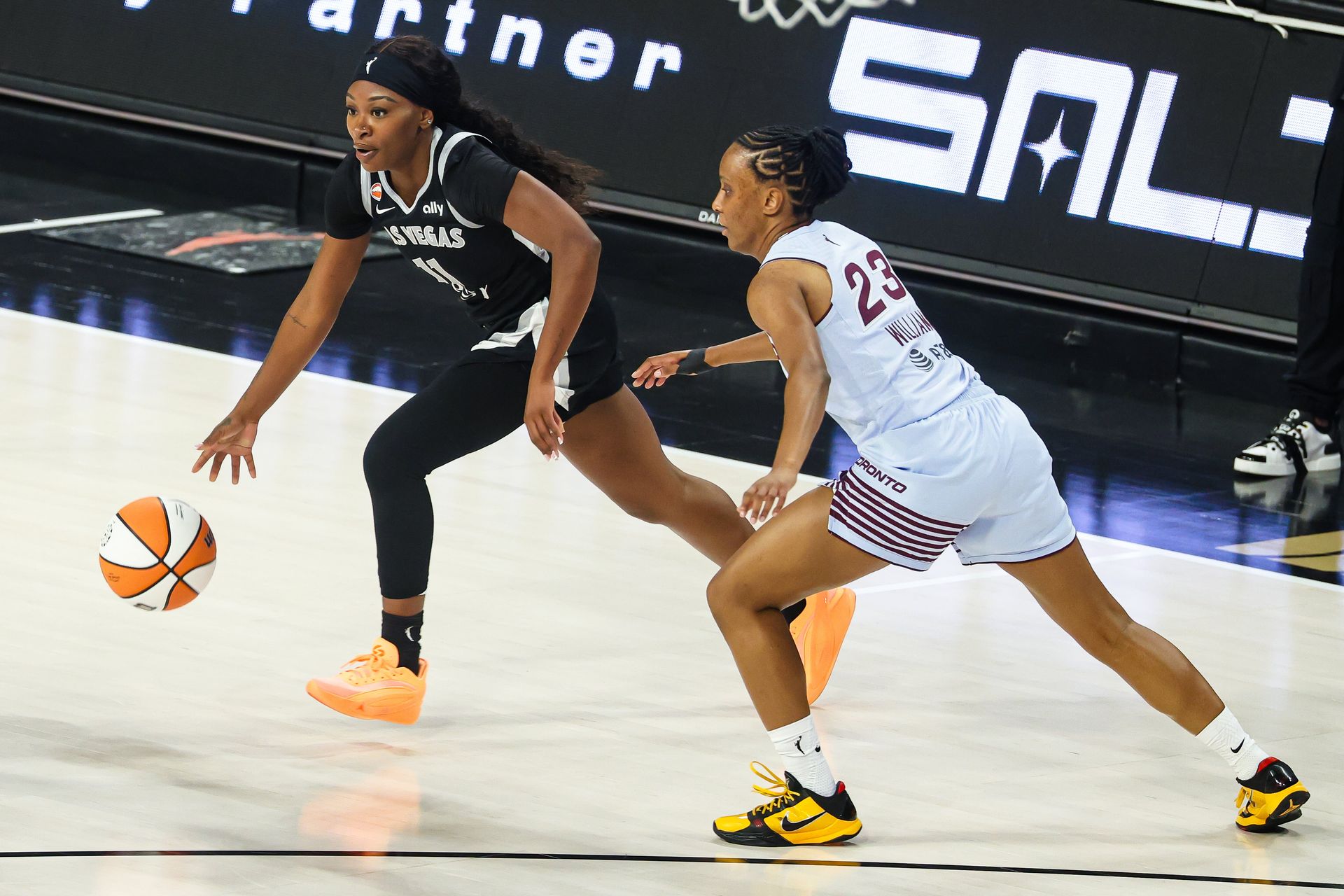 Dana Evans runs with the ball guarded by Kiana Williams.