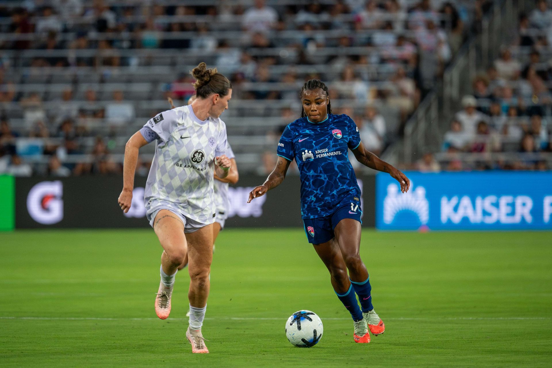 Ludmila dribbles to goal before being tackled in NWSL game against Racing Louisville