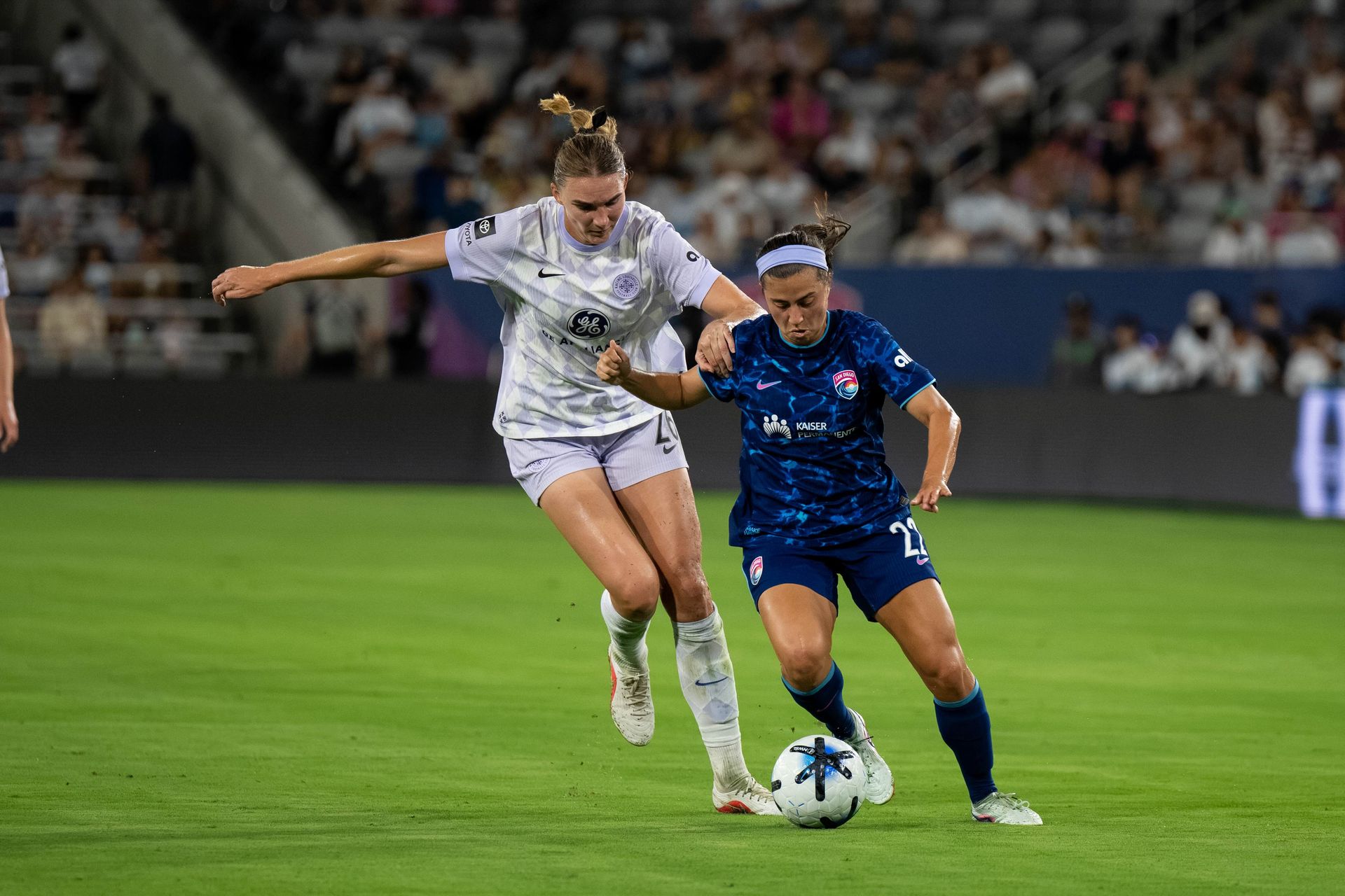Lia Godfrey battles Taylor Flint in midfield during NWSL game