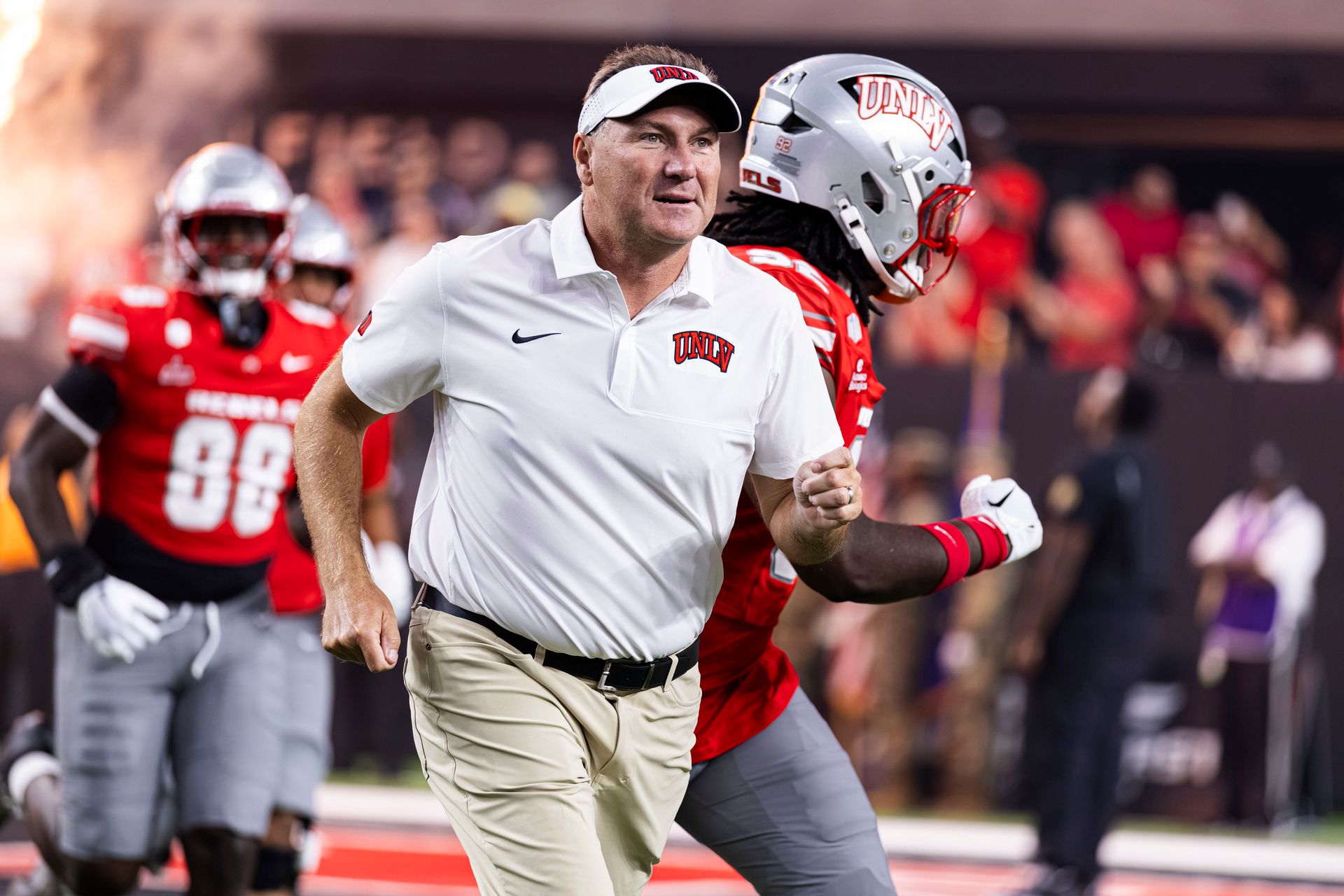 Coach Dan Mullen runs out with UNLV team