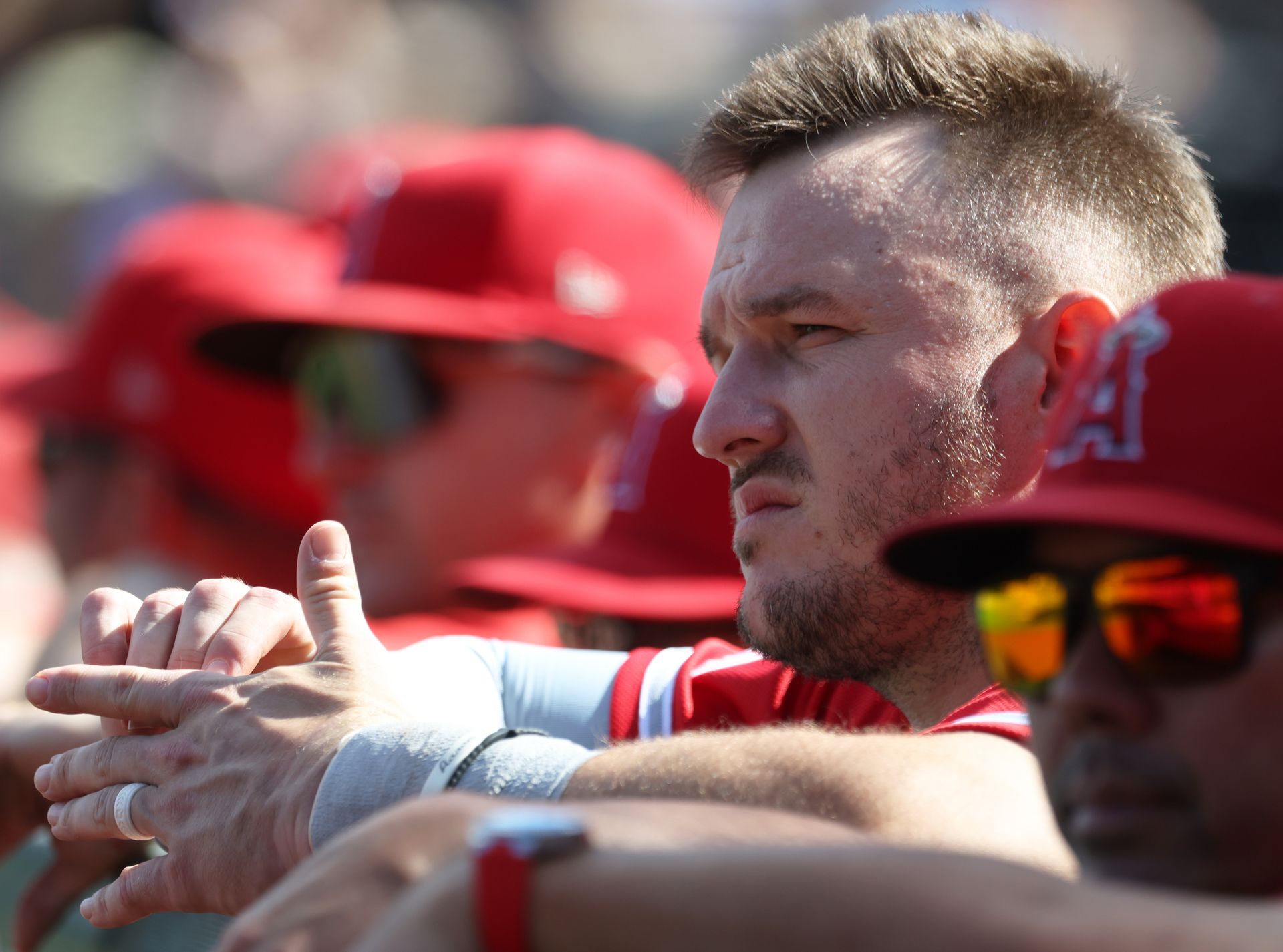 Mike Trout watches from the dugout during the ninth inning
