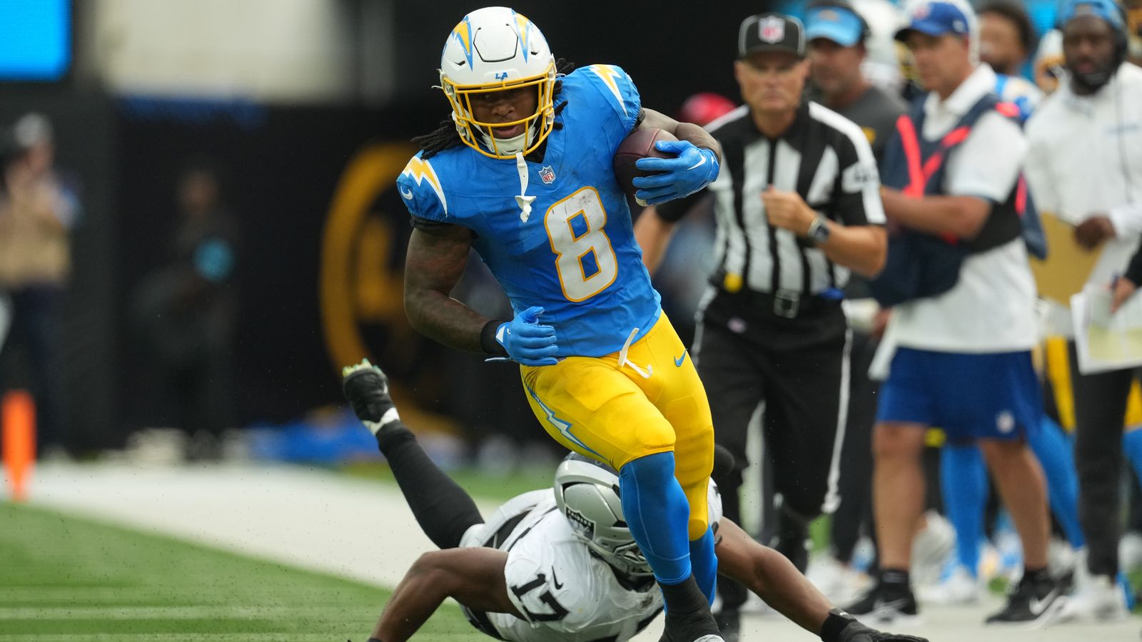 Omarion Hampton evades Raiders defense at SoFi Stadium.