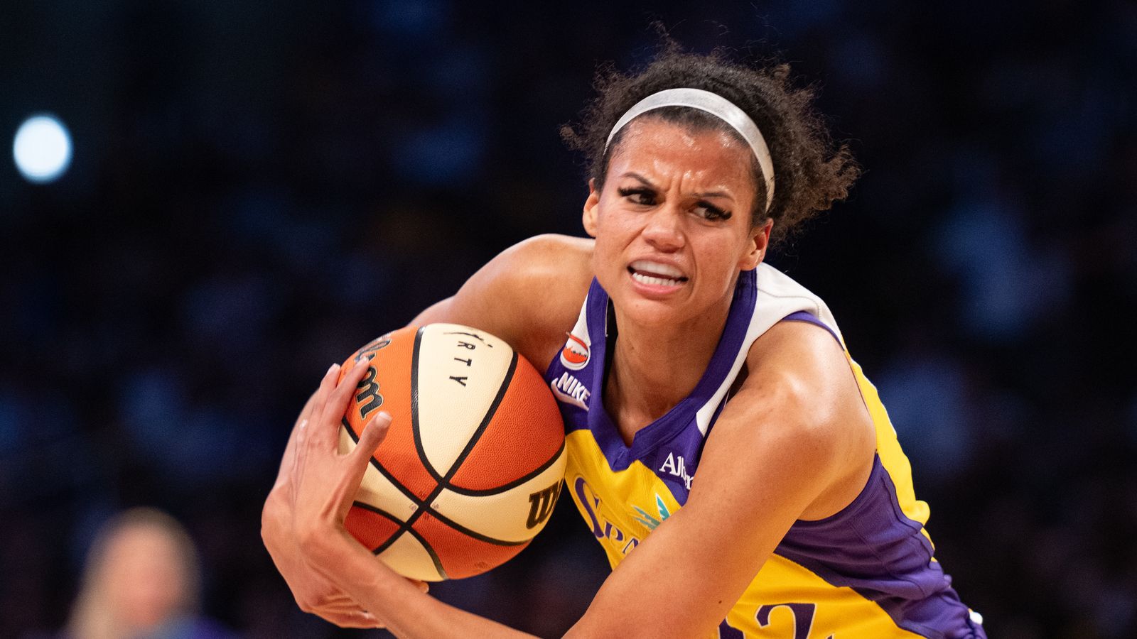 Los Angeles Sparks guard Rae Burrell drives hard to the basket against New York Liberty.