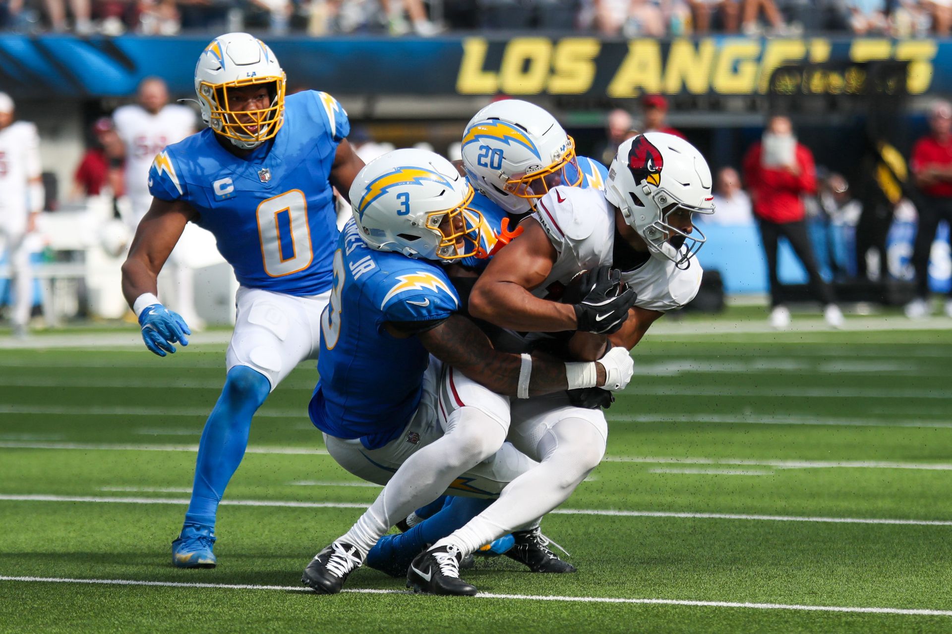 Derwin James and Cam Hart tackle a Cardinals player