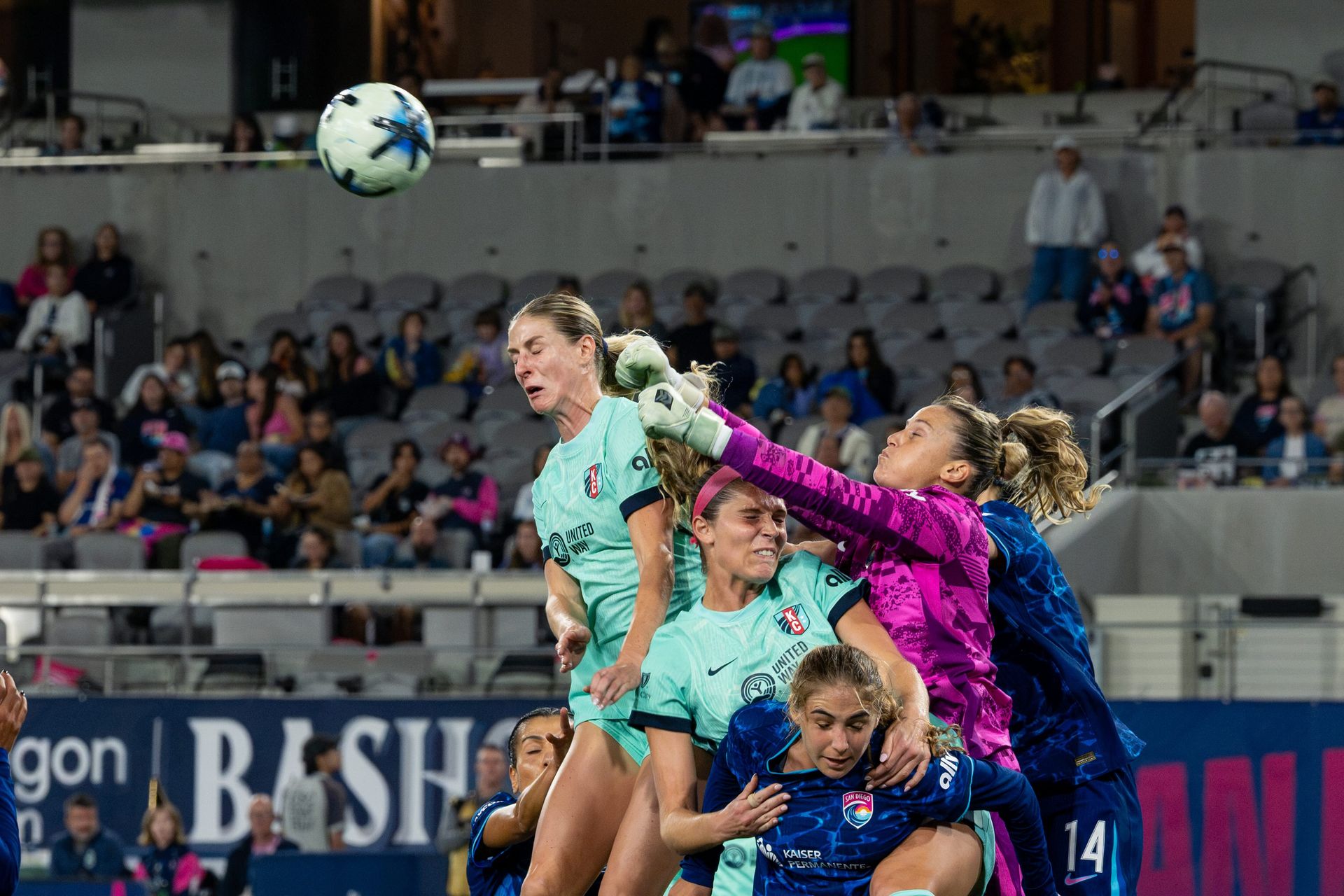 Goalkeeper Sandra Paños punches the ball during a defensive moment.