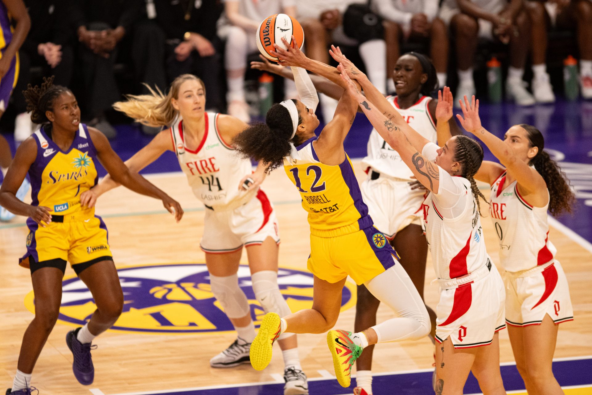 Rae Burrell drives against three defenders in WNBA game.