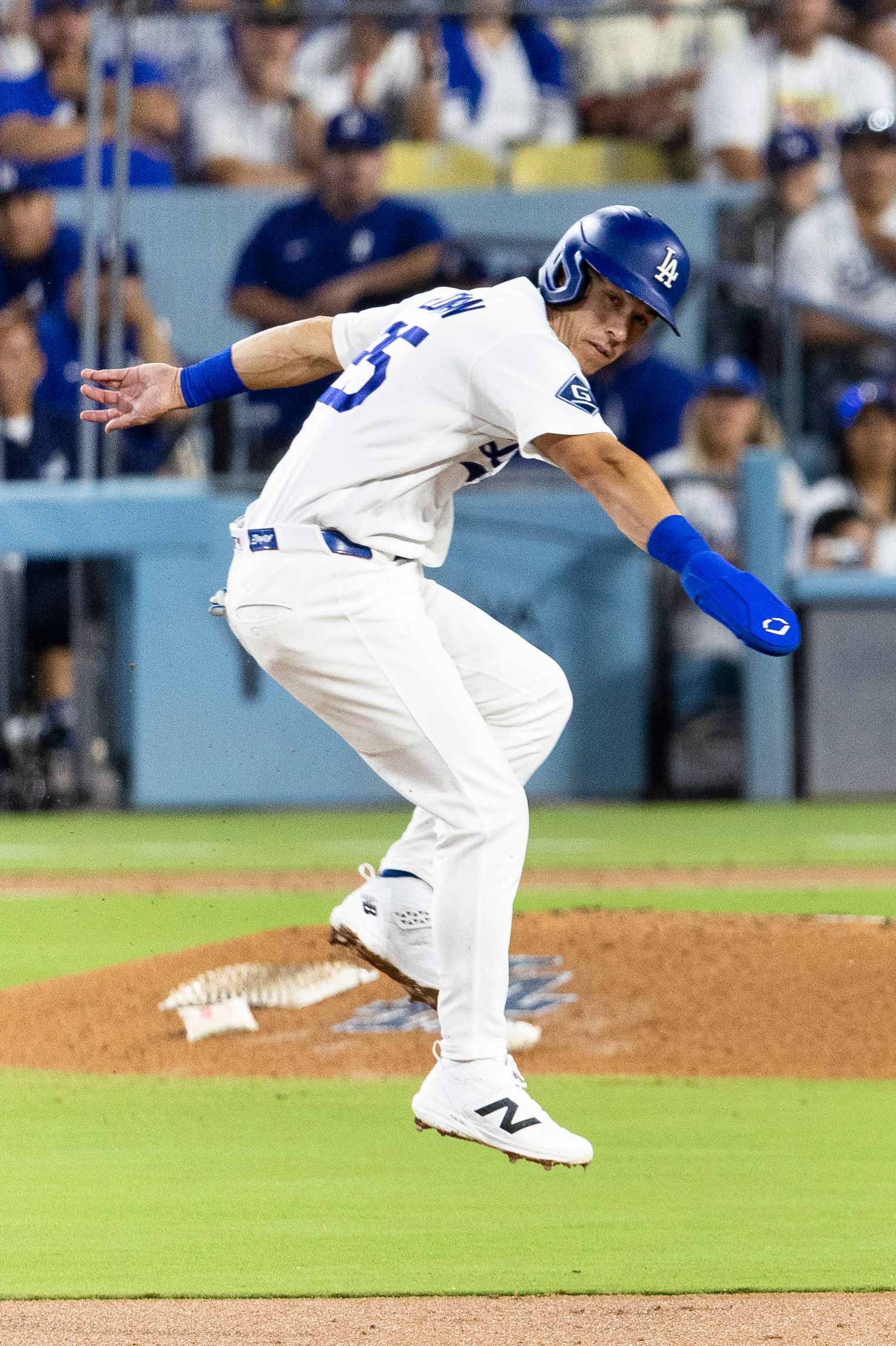 Tommy Edman (25) evades the ball while running bases against Padres.