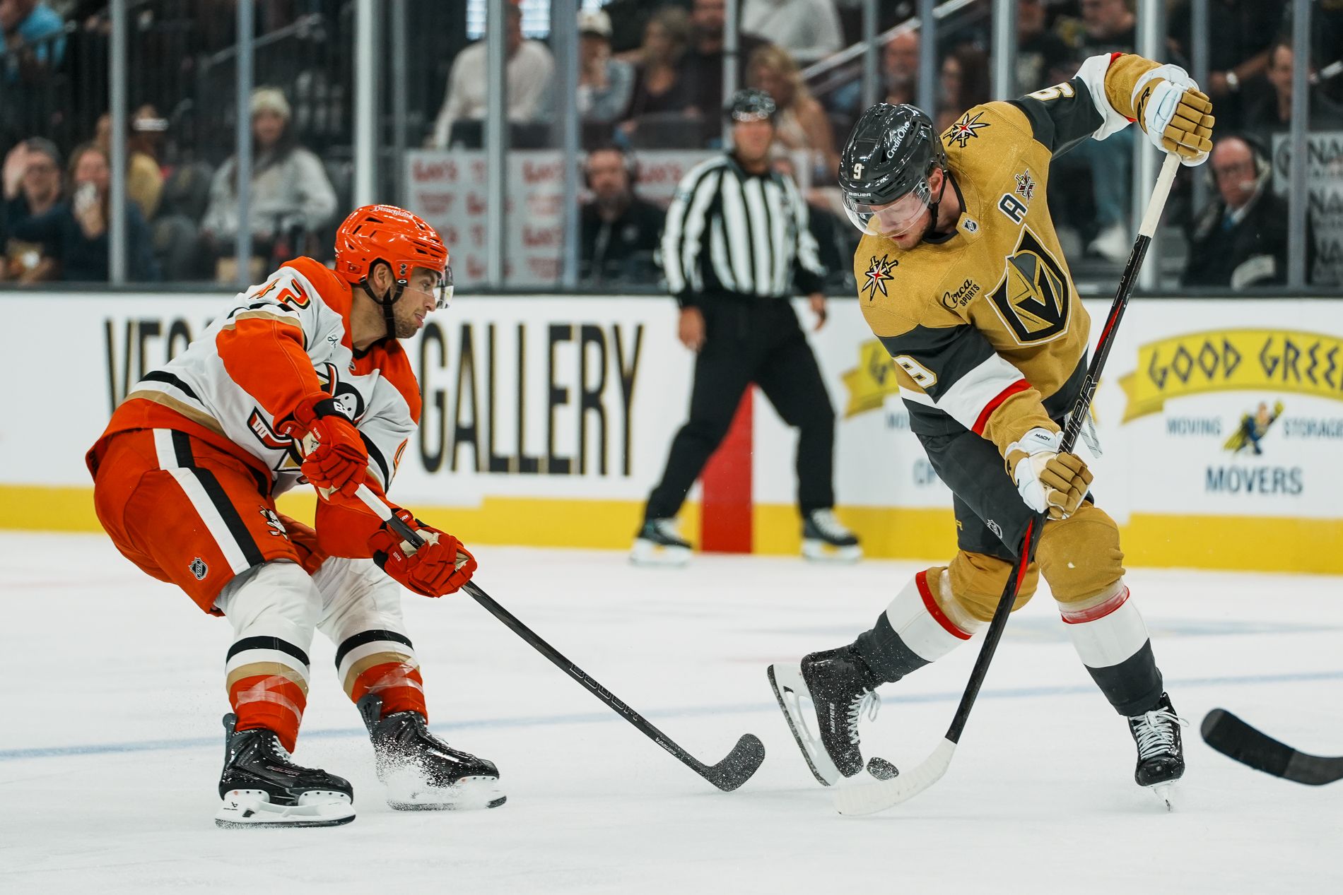 Jack Eichel leads the puck with Tim Washe trailing in a tense NHL game.